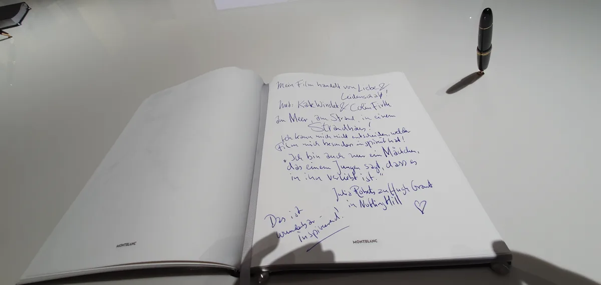 Aufgeschlagenes Gästebuch mit handschriftlichem Eintrag über inspirierende Liebesfilme, daneben ein schwarzer Montblanc-Füllfederhalter.